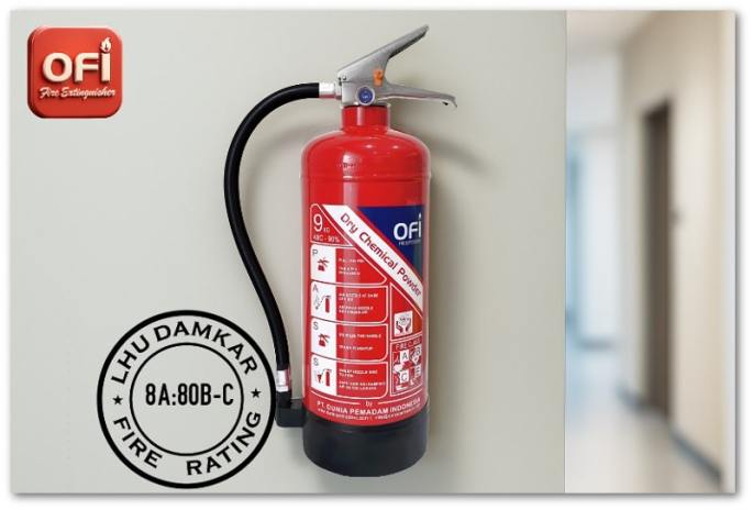 Apar Dry Chemical Powder OFI tampak tergantung di sebuah dinding ruangan.